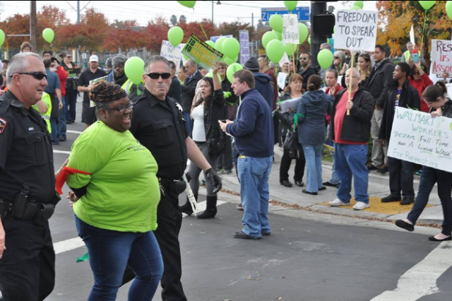 A Wal-Mart protester is led away during a Black Friday action in Sacramento, California. (Photo via Making Change at Walmart.)